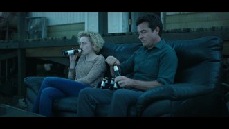 Woman and man drinking larger on sofa