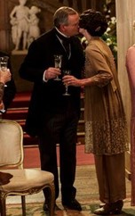 Image of man and woman sharing a kiss while both holding a glass of champagne