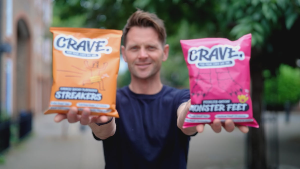 Aldi's Next Big Thing winner, Rob Brice, holding two packets of his winning crisps