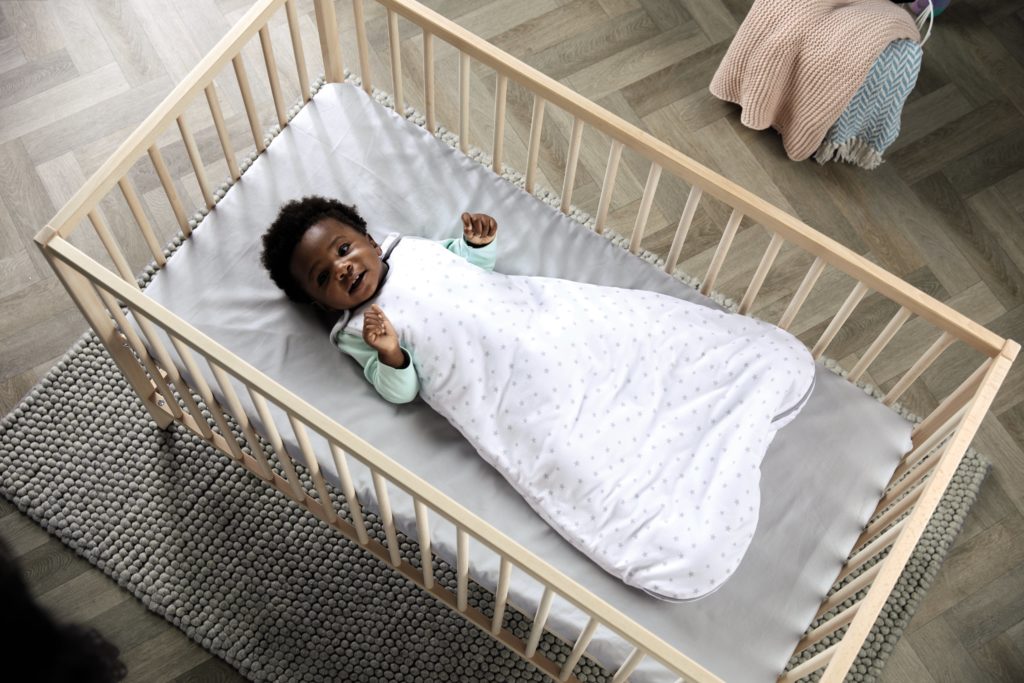Baby settled in a cot whilst in Aldi's snuggle nest 