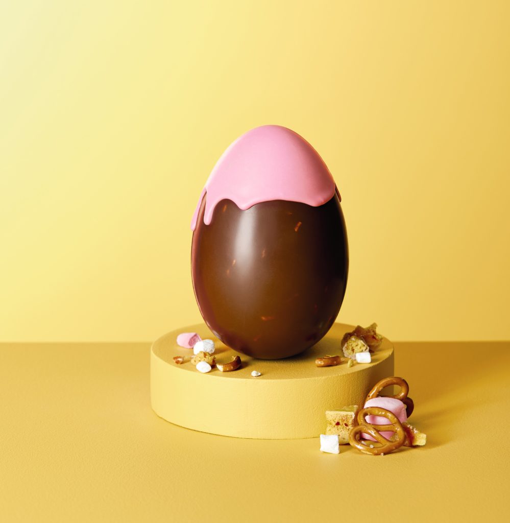 Milk chocolate egg with pink coloured chocolate drizzle over the top