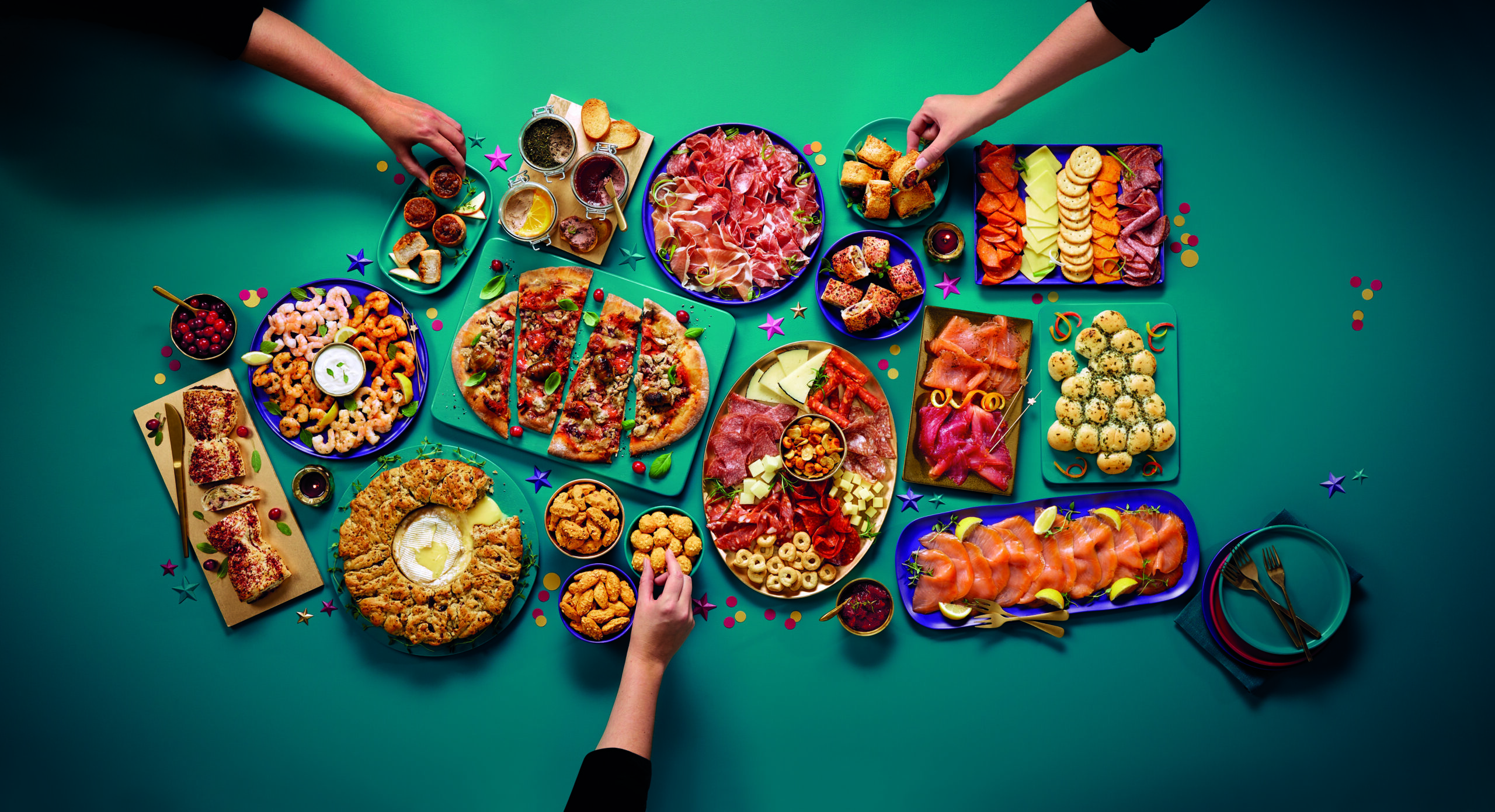 Aldi's Christmas party food range arranged as a platter including pizza, meats, cheeses, cheese, and more