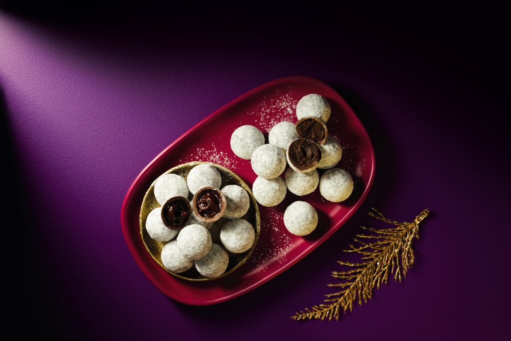 Dusted truffes in a gold bowl and on a red plate. Garnished with a gold leaf.