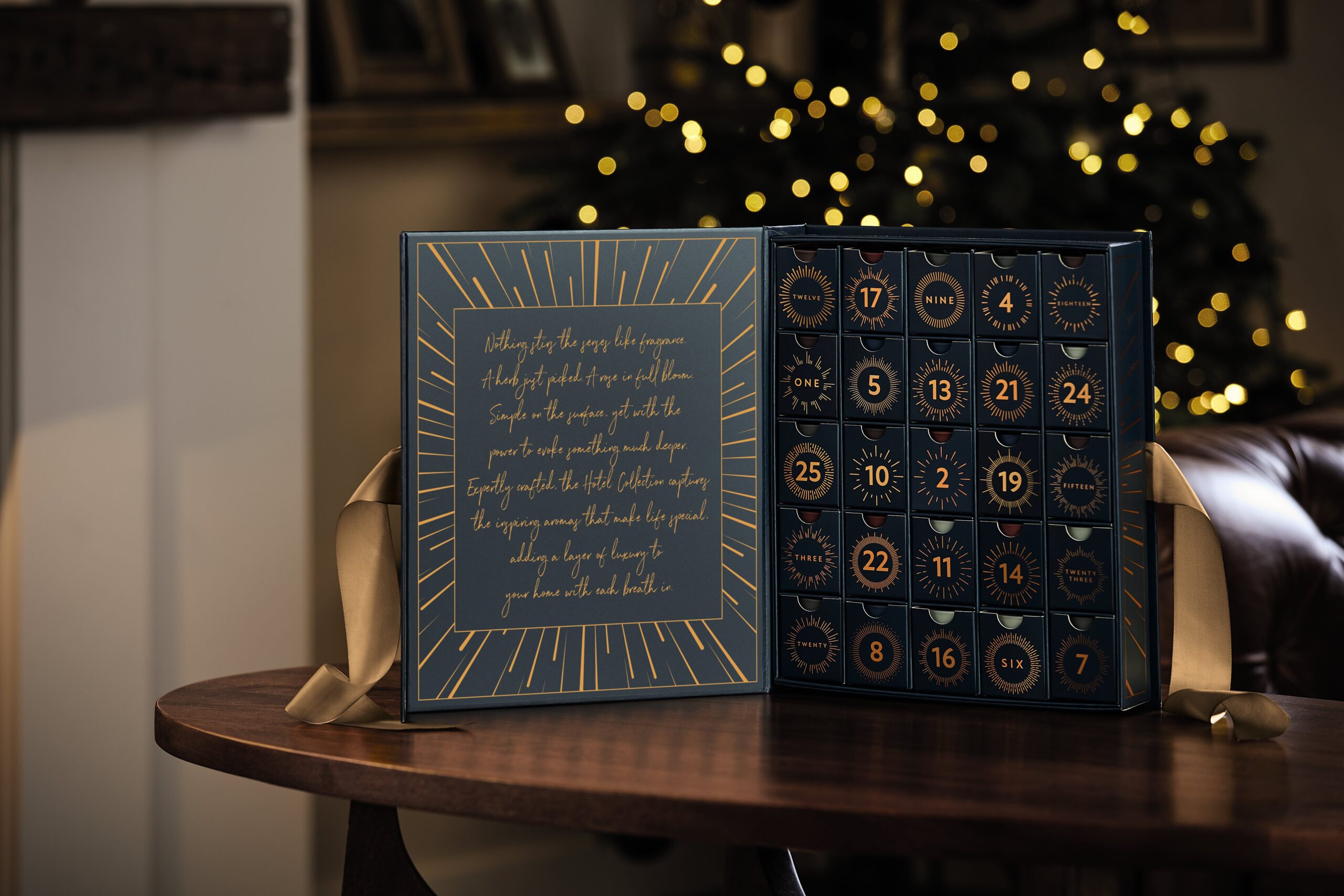 Candle advent calendar open to show the different doors. Dark blue box with gold writing and accents.