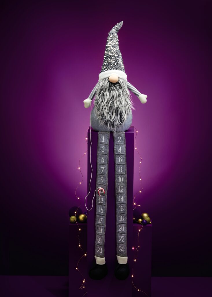 Plush advetntcalendar. Gonk with long grey beard and silver pointy hat, with legs attached that contain the advent calendar pockets.