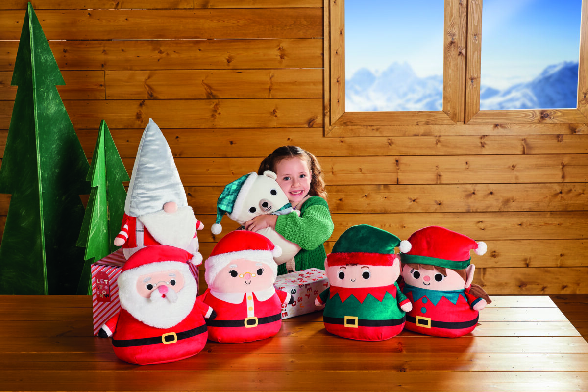 A child cuddling with a collection of Christmas squishees.